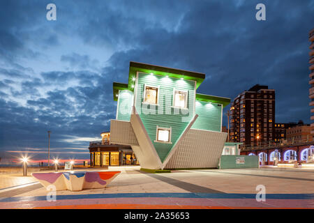 La notte scende al 'Capovolto casa' a Brighton Seafront, East Sussex. Foto Stock