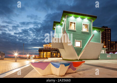 La notte scende al 'Capovolto casa' a Brighton Seafront, East Sussex. Foto Stock