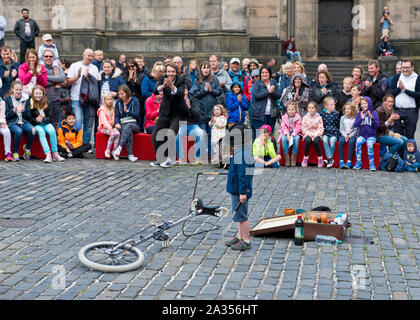 Ragazzo dal pubblico godendo di prendere parte in atto di strada. Edinburgh Fringe Festival Foto Stock