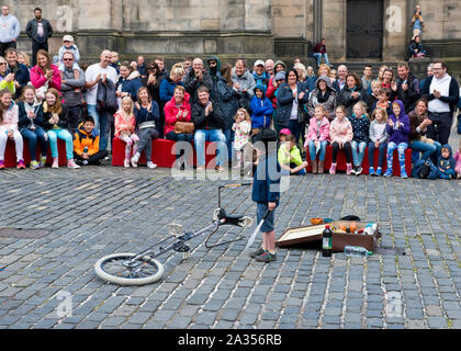 Ragazzo dal pubblico godendo di prendere parte in atto di strada. Edinburgh Fringe Festival Foto Stock