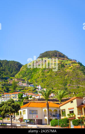 Bel villaggio Porto Moniz in portoghese l'isola di Madeira. Verde costa settentrionale dell'isola. Piccola città in Portogallo circondata da verdi montagne. Paesaggi sorprendenti. Luoghi turistici. Foto Stock