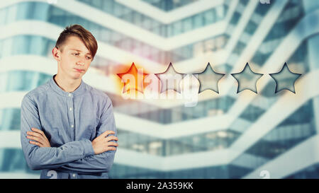 Deluso ragazzo adolescente mantiene con le braccia incrociate cercando orinato oltre ad essere scettico, scegliendo una stella. Cattivo e il servizio clienti poveri concetto. N Foto Stock