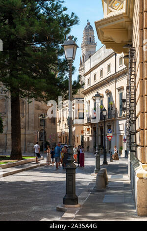 I turisti sulla Via degli Ammirati con Lecce Duomo torre campanaria della distanza - Lecce, Puglia (Puglia) nel Sud Italia Foto Stock