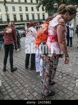 Londra, Regno Unito. 05 ott 2019. Mentre la maggior parte di questo decennio i partecipanti alla giornata di zombie in London ,sceglie di vestire e utilizzare fino a guardare come scary come possibile ,questo gruppo sceglie di andare per la resistenza agli urti, consentendo loro di essere tirato da ganci fissati alla loro indietro attraverso le strade di Londra . Paolo Quezada-Neiman/Alamy live News Foto Stock