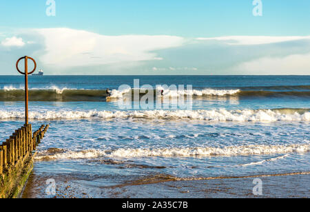 Due surfisti su schede a Aberdeen City Beach, Scozia Foto Stock