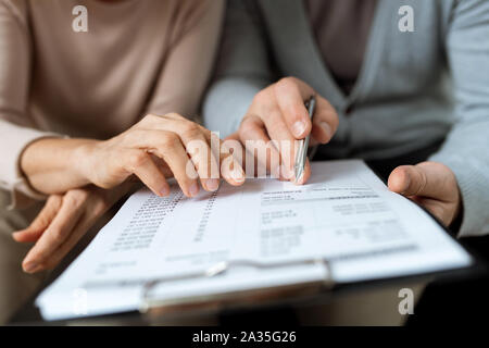 Due mani puntando al documento mentre discute i termini e i punti di contratto Foto Stock