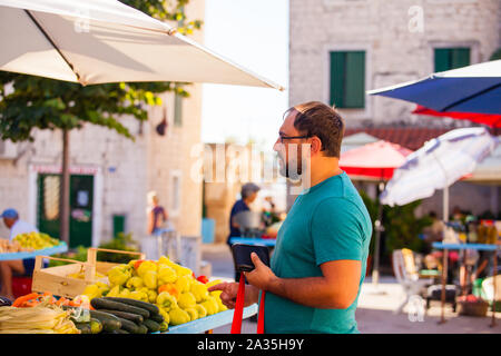 Uomo a tutti i giorni di mattina outdoor vegetale di mercato Foto Stock