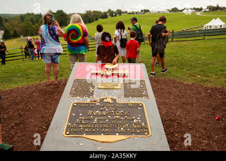 08192019 - Bethel, New York, Stati Uniti d'America: un ragazzo tocca l'uccello in Woodstock memorial vicino al sito dell'originale principale fase di Woodstock, in background, Lunedì, Agosto 19, 2019 a Bethel boschi a Bethel, New York. Organizzatore di Woodstock Michael Lang la manifestazione è stata annullata, ma le attività di anniversario ha continuato ad Arrowhead Ranch, Bethel Woods (sito dell'originale Woodstock in 1969), Hector's Inn e Yasgur's Farm. Foto Stock