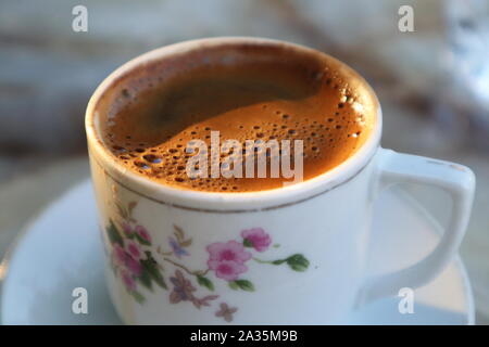 Tazza di caffè turco con la schiuma e illuminazione soffusa Foto Stock