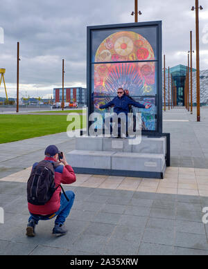 Giochi di troni omaggio macchia finestra di vetro si sviluppano dalla città di Belfast. Tourist in posa di fronte al Trono di ferro, impostare esplicitamente per che featu Foto Stock