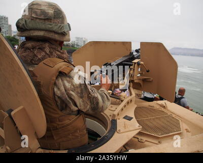 Marina peruviana la manipolazione di una Cal .50 BMG mitragliatrice sulla parte superiore di un blindato di veicolo anfibio (ASLAV-II) a Miraflores Bay durante il "Velas Latinoamerica 2018' evento nautico, che avrà luogo a Lima in Perù. L'evento congregates 10 di formazione di navi a vela da paesi latino-americani e la Spagna. Foto Stock