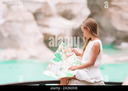 Adorabile bambina guardando mappa turistica vicino a Fontana di Trevi, Roma, Italia. Felice toodler kid godere di vacanza italiana vacanza in Europa. Foto Stock