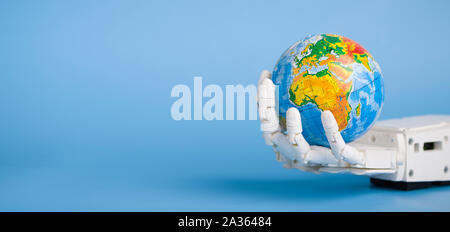 Globo in mano di robot, blue panorama sullo sfondo Foto Stock