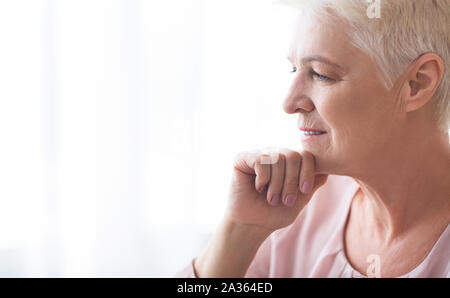 Side Shot di pensieroso senior lady cercando riposo Foto Stock