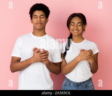 Tipo di cuore ragazzi tenendo le mani compresi sul petto Foto Stock