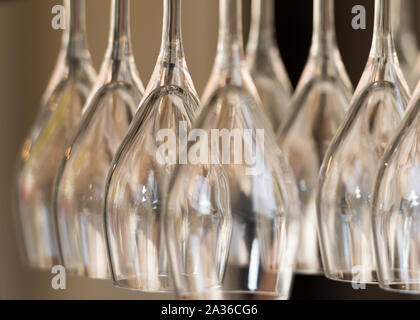 Bicchieri di vino appeso a testa in giù in un banco di bar. Immagine ravvicinata. Foto Stock