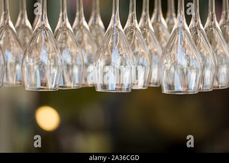 Bicchieri di vino appeso a testa in giù in un banco di bar. Immagine ravvicinata. Foto Stock