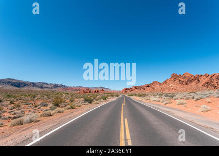 La guida su piccole Park Road con grandi formazioni montuose tutti intorno a Foto Stock