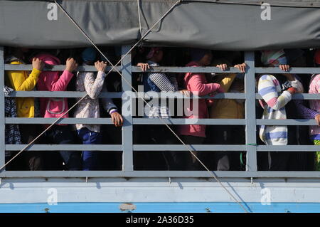 Indumento sovraffollamento dei lavoratori nella parte posteriore di un carrello, il pendolarismo a casa dopo il lavoro, Phnom Penh Cambogia. © Kraig Lieb Foto Stock