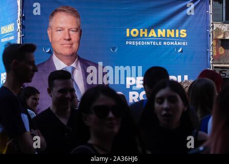 Bucarest, Romania - 30 Settembre 2019: i giovani passano da un cartellone pubblicitario della campagna elettorale di Klaus Iohannis, presidente della Romania, che ho Foto Stock