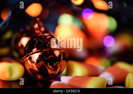 Vista dettagliata del metallo arancione Jack O' Lanterna campana con la caramella di mais e Halloween Led luce Bokeh (sfumata) Contesto Foto Stock