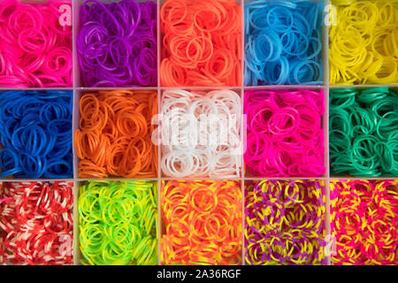 Colorate texture di sfondo multicolore di nastri elastici disposti in vani quadrati in una scatola visto dal sovraccarico in frame completo Foto Stock