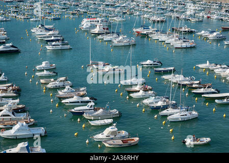 Angolo di alta vista delle barche e yacht allineati durante galleggiamento in acqua di mare ormeggiata in un marina durante una giornata di sole di estate Foto Stock