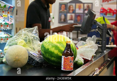 Middletown, CT, Stati Uniti d'America. Sep 2019. Frutta fresca e verdure e una bottiglia di tè fermentato o il Kombucha sul convogliatore del negozio per l'acquisto. Foto Stock