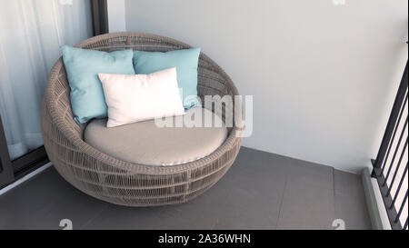 Outdoor sedia spiaggia sul balcone della camera o terrazza che fece di legno naturale chiamato rattan e colore marrone forma rotonda e cercare di lusso per ri Foto Stock