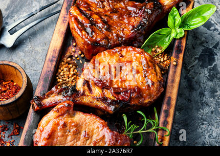 Piccante grigliate di costine sul tagliere di legno.La carne di maiale alla griglia su rack Foto Stock