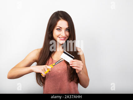 Bella grave arrabbiato donna il taglio la sua carta di credito su sfondo blu con copia vuota dello spazio. Ritratto Foto Stock