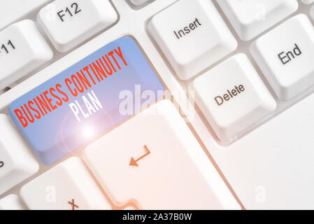 Testo della grafia piano di continuità aziendale. Foto concettuale la creazione di sistemi prevenzione affrontare potenziali minacce White tastiera PC con vuoto carta nota Foto Stock