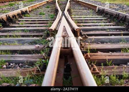 Due binari ferroviari si fondono insieme. Incrocio ferroviario Foto Stock