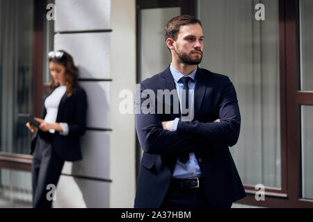 Grave ragazzo fiducioso in elegante abito cercando in disparte, imprenditrice in abiti eleganti sutfing, la navigazione in Internet. close up foto. Foto Stock