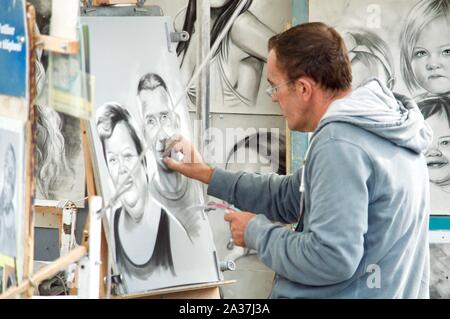 Un artista abbozzare un ritratto a Cap d'Agde, Francia Foto Stock
