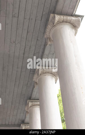 Elemento di una vecchia colonna contro un soffitto in legno. Elemento d'epoca di costruzione tecnica. L'elemento della colonna bianca sotto il soffitto. Foto Stock