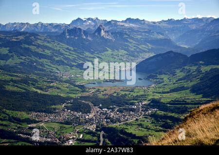 Paesaggio panoramico vista sul Lago di Lauerz circondato da prati, catene montuose e cime innevate dalla sommità del Monte Rigi Kulm, Monte Rigi in Swi Foto Stock