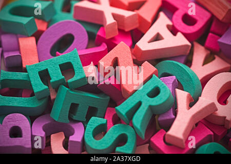 Pila di colorati di legno verniciato di lettere. Tipografia composizione dello sfondo. Foto Stock