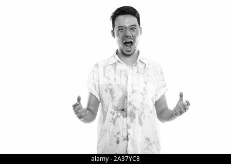 Studio shot di giovani pazzo uomo asiatico sollevando entrambe le braccia e urlando con il sangue sulla faccia Foto Stock