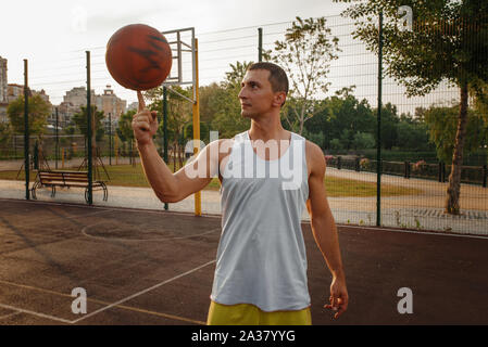 Giocatore di basket la filatura la sfera sul suo dito Foto Stock