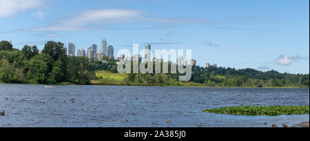 Panorama di Burnaby, British Columbia, Canada skyline da Deer Lake guardando verso il Metrotown e i complessi di appartamenti su una soleggiata giornata estiva. Foto Stock