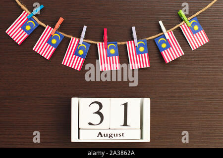 Bandiere di Malaysia sul stendibiancheria attaccato con clothespins in legno e calendario in legno Foto Stock