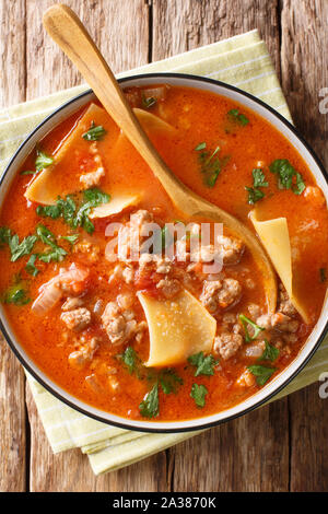 Le lasagne italiane zuppa close-up in una piastra sul tavolo. Verticale in alto vista da sopra Foto Stock