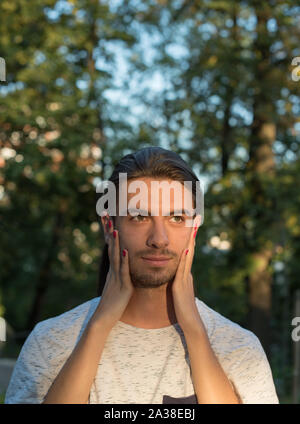 Donna di mani su un il volto dell'uomo Foto Stock