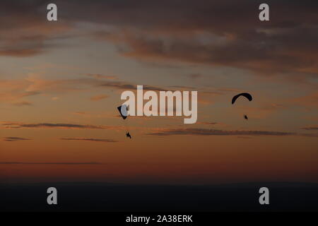 Coppia di powered parapendii in volo sopra il Sussex Southdowns durante un tramonto mozzafiato. Foto Stock