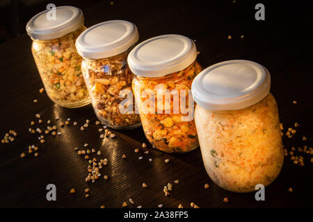 Vasetti di lenticchie fresche, granola, noci e semi Foto Stock