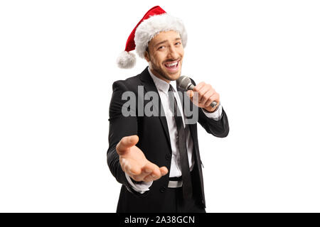 Bella cantante maschio in un vestito nero cantando su un microfono e indossa una Santa Claus hat isolato su bianco backround Foto Stock