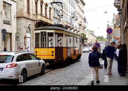 Antico, storico, trolley, tram con traffico e gente, in Via Alessandro Manzoni, Milano, Italia. Foto Stock