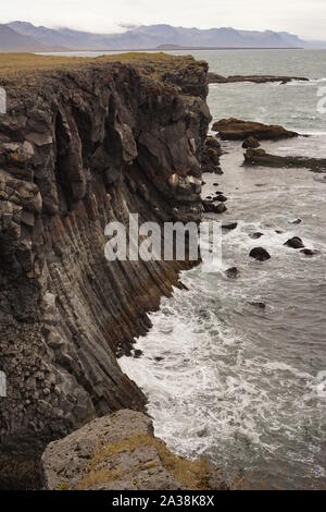 Le onde del mare a schiantarsi sulla roccia di basalto colonne cliff edge Foto Stock