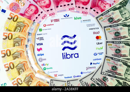 Libra logo Associazione su carta per brochure e USD CNY, le banconote in euro. A titolo illustrativo per Facebook piano per creare moneta mondiale chiamato libra. Foto Stock